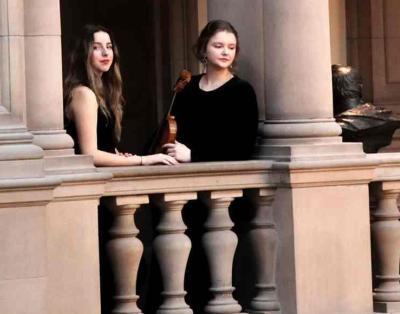 Ros-Turowska Duo stood looking out over a stone balcony between two pillars.